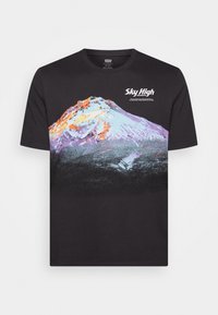 Svart grafisk t-shirt med ett bergstryck i lila, orange och vita färger; "Sky High"-text ovanför designen. Korta ärmar, rundad hals.