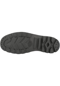 Suola in gomma nera con un motivo di battistrada robusto, che presenta design a zigzag e circolari per la trazione, e fori di drenaggio vicino all'area delle dita.
