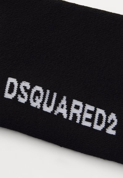 Sort stofhovedbånd med en tekstureret overflade, der viser det hvide "DSQUARED2" logo i en fed, moderne skrifttype.