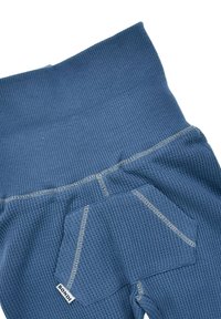 Blaue thermo Leggings mit gerippter Textur, breitem Bund und einer Seitenasche mit kontrastierenden Nähdetails. Markenlabel sichtbar.