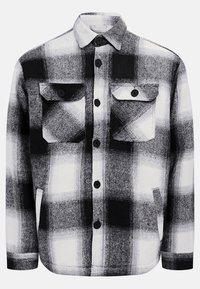Chemise en flanelle à carreaux noir et blanc, avec deux poches avant, des boutons et une texture douce. Motif tartan classique.