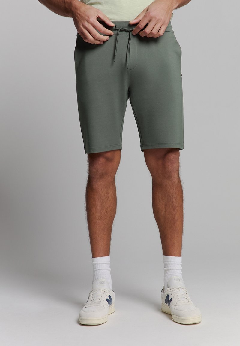 Groene, knielange shorts gemaakt van zachte stof met een elastische tailleband en trekkoord. Voorzien van zijzakken en een slim fit ontwerp.