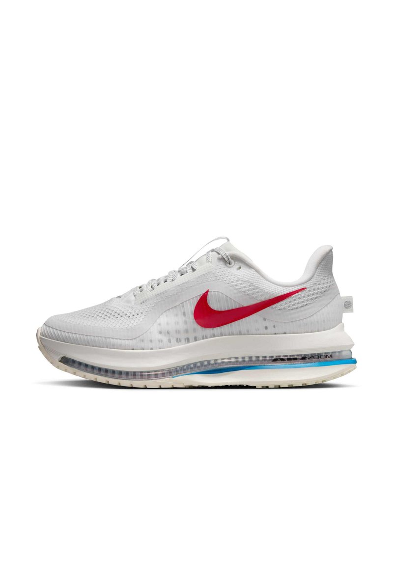 Chaussure de sport blanche avec un dessus en mesh respirant, un emblématique swoosh rouge de Nike, une semelle rembourrée avec des accents bleus et des détails texturés.