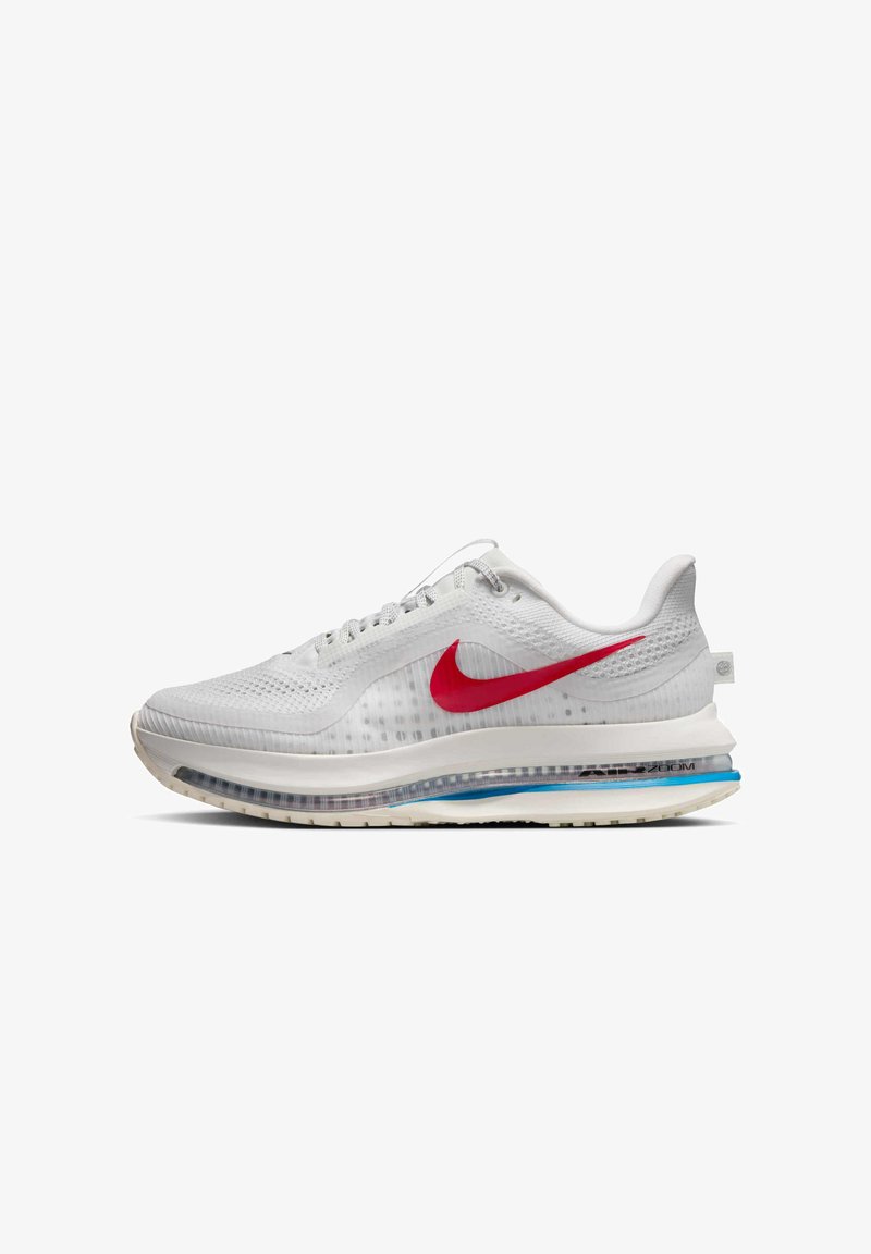 Chaussure de sport blanche avec un dessus en mesh respirant, un emblématique swoosh rouge de Nike, une semelle rembourrée avec des accents bleus et des détails texturés.