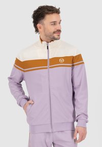 Lavender zip-up jacket with cream and rust horizontal stripes, featuring a high collar, side pockets, and a logo on the chest. Smooth texture.