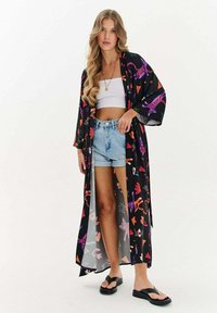 Dlouhý černý kimono s barevnými květinovými a zvířecími vzory; lehký materiál, široké rukávy, otevřený přední díl, spárováno s crop topem a šortkami.