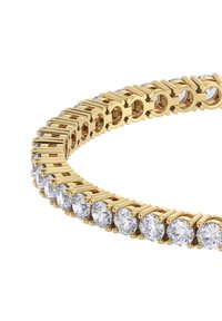 Bracciale in tono oro con pietre trasparenti rotonde incastonate in un design a catena, che presenta una superficie liscia con accenti alternativi di metallo e pietra.