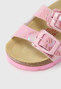 Roosa libisev sandaal kahe reguleeritava pandlaga, tekstureeritud sünteetiline pealne, korkjalaga ja roosa kummipõhjaga, millel on peened läikivad detailid.