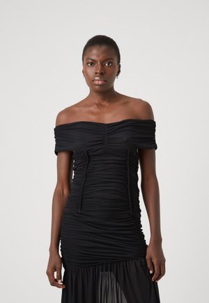 Abito nero fuori spalla con tessuto arricciato, texture senza cuciture e silhouette aderente. Presenta una gonna trasparente a strati e lacci regolabili.