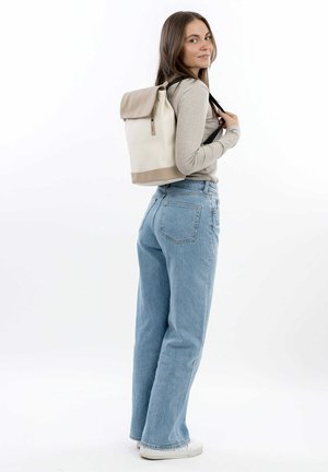 Backpack in cream and beige material with a roll-top design, adjustable black straps, and subtle hardware details. Textured surface.