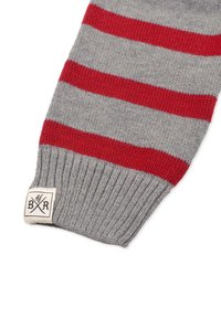 Grå stickad scarf med röda horisontella ränder, med ribbat mönster och en krämfärgad etikett med svart logotyp i ena änden.