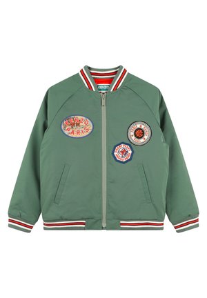 Groene bomberjack met gestreepte geribbelde kraag en manchetten. Ritssluiting aan de voorkant, met vier geborduurde patches in verschillende kleuren en vormen.
