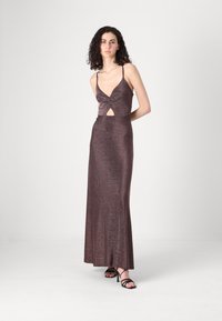 Rochie maxi dintr-un material strălucitor, bronz închis. Dispune de un decolteu adânc în formă de V, detaliu răsucit la bust și o decupare la talie. Bretele subțiri.