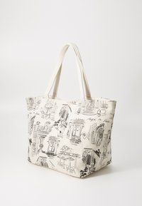 Platnena torba u krem boji s crnim ilustracijama trgovina i kafića. Ima duple tekstilne ručke i prostran pravokutni oblik.