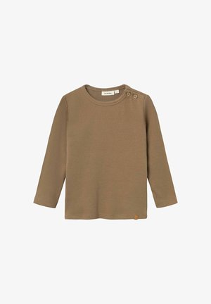 Maglietta marrone a maniche lunghe con coste, colletto rotondo e due bottoni decorativi sulla spalla sinistra. Piccola etichetta del brand in basso a sinistra.