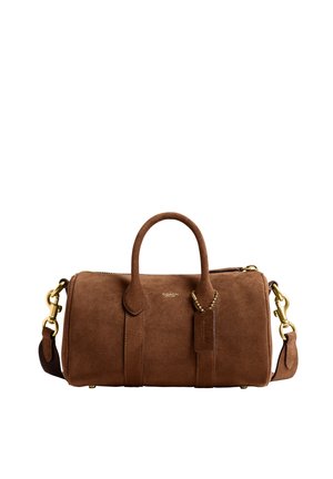 Sac de voyage Coach en daim marron avec poignées supérieures, bandoulière amovible, ferrures dorées et une étiquette en cuir.