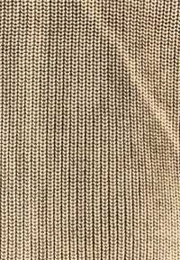 Knitted fabric in beige and dark brown, featuring a ribbed texture with interlocking yarn patterns, creating a layered appearance.