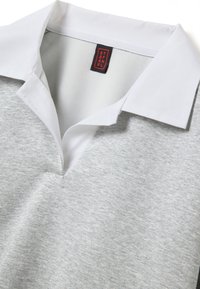 Grijze sweater met een witte, omgeslagen kraag. Zachte textuur, V-hals ontwerp en een rood label aan de binnenkant met de tekst "STEFANEL."