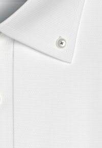 Witte polo shirt met een gestructureerde stof, een scherpe kraag en een enkele ronde knop met een donkere center. Close-up weergave.