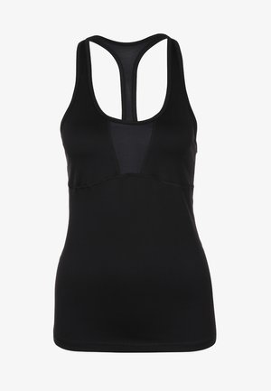 Vrouw staand, draagt een zwart mouwloos sporttopje, grijze legging met patroon en zwarte zijpanelen, en zwarte en paarse hardloopschoenen.