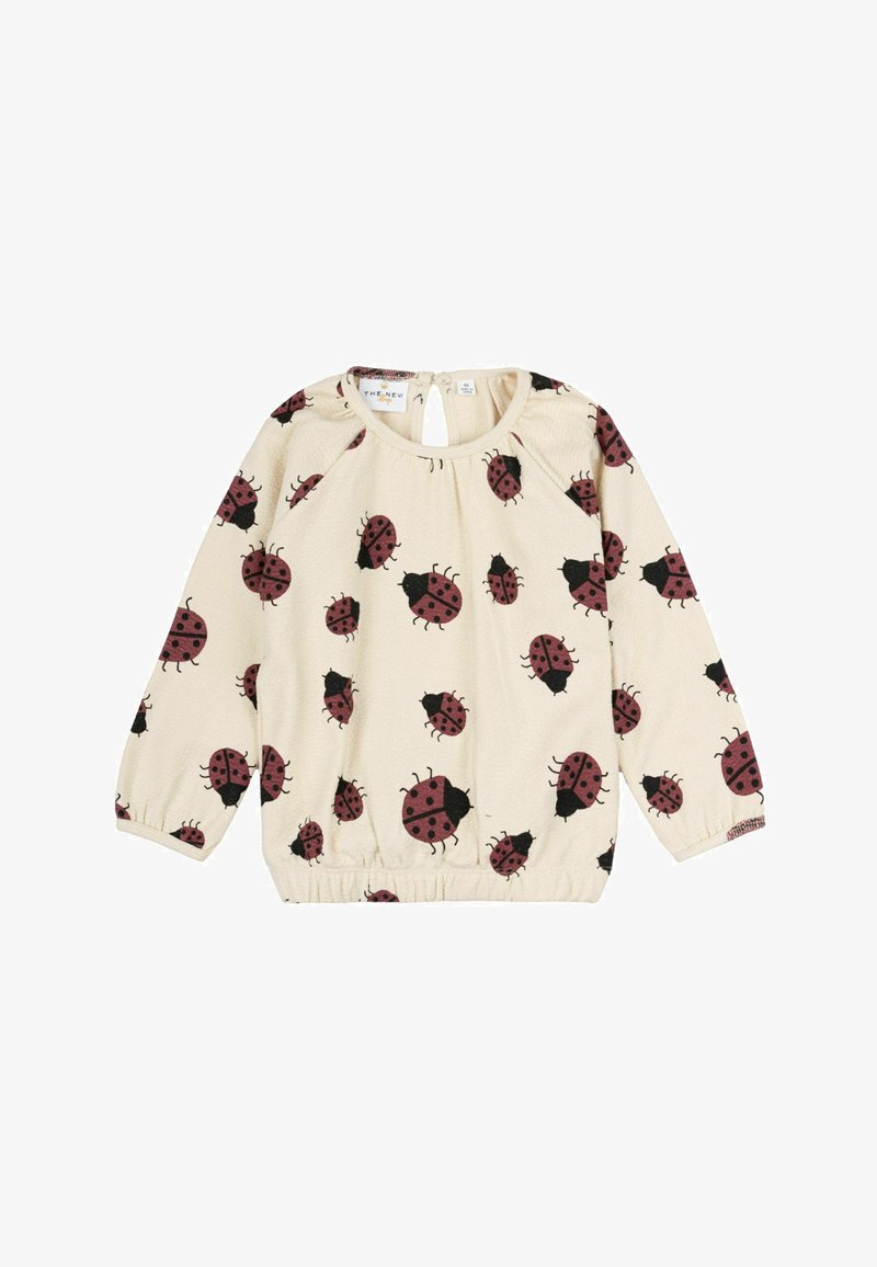 Kremna dolga majica z dolgimi rokavi z elastičnim robom ima vzorčno obliko s črnimi in burgundskimi pikapolonami. Detajl s ključavnico na hrbtni strani izboljšuje dizajn.