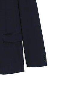 Navyblå kavaj med strukturerad yta, en bröstficka och detaljer med tre knappar på ärmen. Skräddarsydd passform.