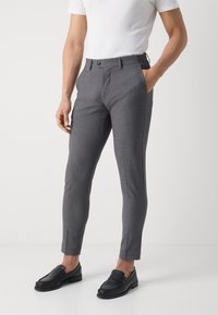 Gray slim-fit trousers made from a textured fabric, featuring a buttoned waistband and side pockets. Worn with a white t-shirt and black loafers.