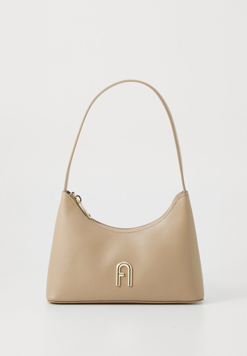 Bežs ādas rokassoma ar izliekotu siluetu, zelta aksesuāriem un rāvējslēdzēja aizdari. Iespējams nēsāt ar vienu pleca siksnu.