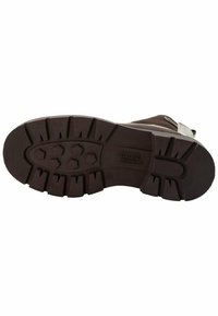 Suola in gomma marrone con tasselli multidirezionali per migliorare la trazione, una sezione liscia vicino al tallone e un delicato logo del marchio stampato.