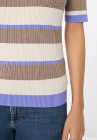 Gebreid gestreept topje met bruin, crème en lavendel kleuren, korte mouwen, geribbelde textuur en een klein logo-detail aan de onderrand.