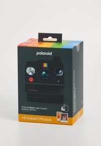 Embalaža kompleta instant kamere Polaroid Now+; črna škatla z barvitimi poudarki, slika kamere in besedilo; vključuje 8 instant fotografij.