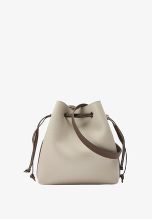 Beżowa skórzana torba w kształcie wiadra z brązowym ściągaczem i regulowanym paskiem na ramię na białym tle.