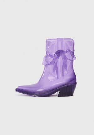 Purple transparent ankle boots with a pointed toe, flared heel, and ruffled accent at the ankle. Made of glossy synthetic material.