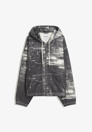 Sort og hvid slidt zip-up hættejakke med hætte, frontlommer, hvide snore og synlige syninger på ærmerne og kanten.