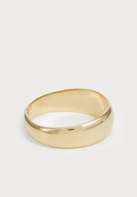 Bracciale rigido oro con superficie liscia e lucida e un design leggermente curvo. Presenta un profilo rotondo senza cuciture.