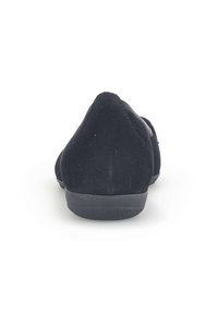Zwarte suède schoenen met een ronde neus en een lage rubberen zool. De achterkant heeft een gladde textuur, wat de slanke, ingetogen vormgeving benadrukt.
