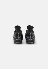 Black football boots with a sleek design, textured mesh upper, low collar, and transparent studded outsole. Features "Mercurial" branding.