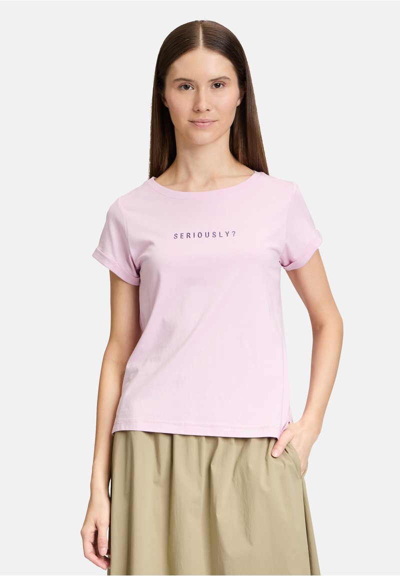 T-shirt rose clair avec un col rond et des manches courtes retroussées, affichant le texte "SÉRIEUSEMENT ?" en violet foncé. Tissu doux, coupe décontractée.