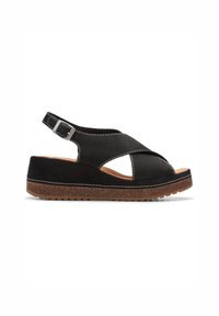 Sandale compensée en cuir noir avec bride ajustable à la cheville, surpiqûres blanches, semelle plateforme à texture liège et design à bout ouvert.