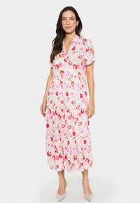 Vestido midi floral en rosa pastel, con cuello tipo camisa y mangas cortas. Hecho de un tejido ligero, con una falda fluidamente caída y un diseño en capas.