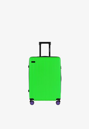 Hardschalenkoffer in felgroen met verticale ribbels, zwarte handgreep en wielen met paarse accenten. Voorzien van een zijvak en een gladde afwerking.
