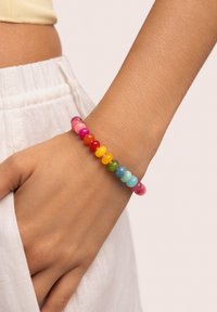 Multicolored bead bracelet featuring round, translucent beads in shades of pink, red, yellow, green, and blue, worn on a wrist.