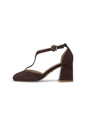 Zapato de tacón para mujer de ante marrón oscuro con tira en T y hebilla redonda decorativa en un tacón grueso de altura media.