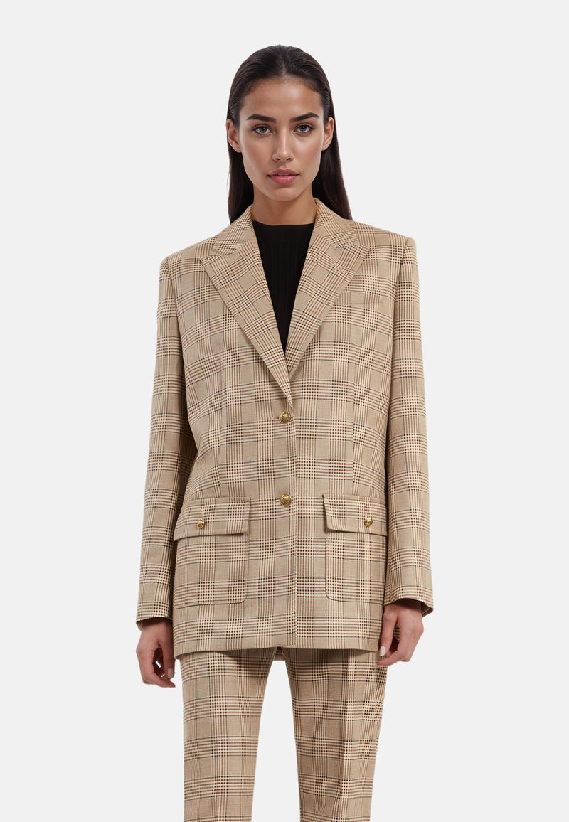 Blazer de cuadros en color beige con un cierre cruzado, solapas anchas, dos bolsillos delanteros y botones dorados, combinado con pantalones a juego.