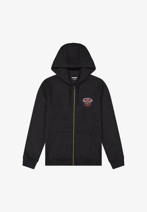 Musta vetoketjullinen huppari etutaskuilla, kiristysnyörillä varustettu huppu, kullanvärinen vetoketju sekä pieni punainen ja valkoinen Wrangler-logo vasemmassa rinnassa.