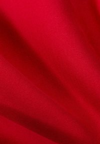 Tissu rouge avec un tissage texturé, affichant un motif cohérent et une draperie fluide. La couleur est vibrante et uniforme dans l'ensemble.