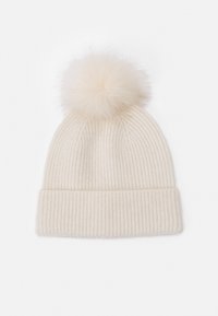 Cream-colored knit beanie with a ribbed texture and a large, soft pom-pom on top. The design is simple and cozy, suitable for winter wear.