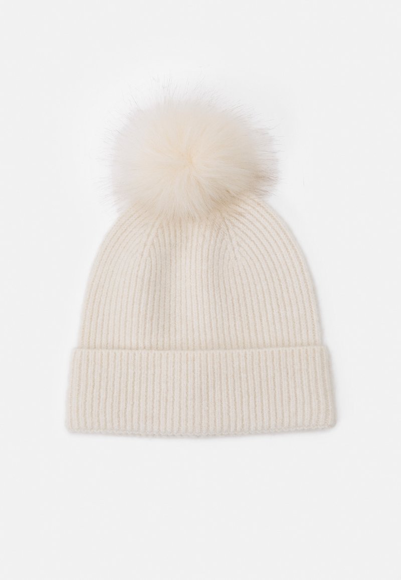 Cream-colored knit beanie with a ribbed texture and a large, soft pom-pom on top. The design is simple and cozy, suitable for winter wear.