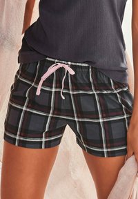 Gepofte shorts in zwart, rood en wit met een elastische tailleband en een roze trekkoord. Gemaakt van een zachte, lichte stof.