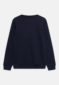 Sudadera de algodón azul marino con cuello redondo, mangas largas y puños acanalados con una textura suave. Vista trasera mostrada.